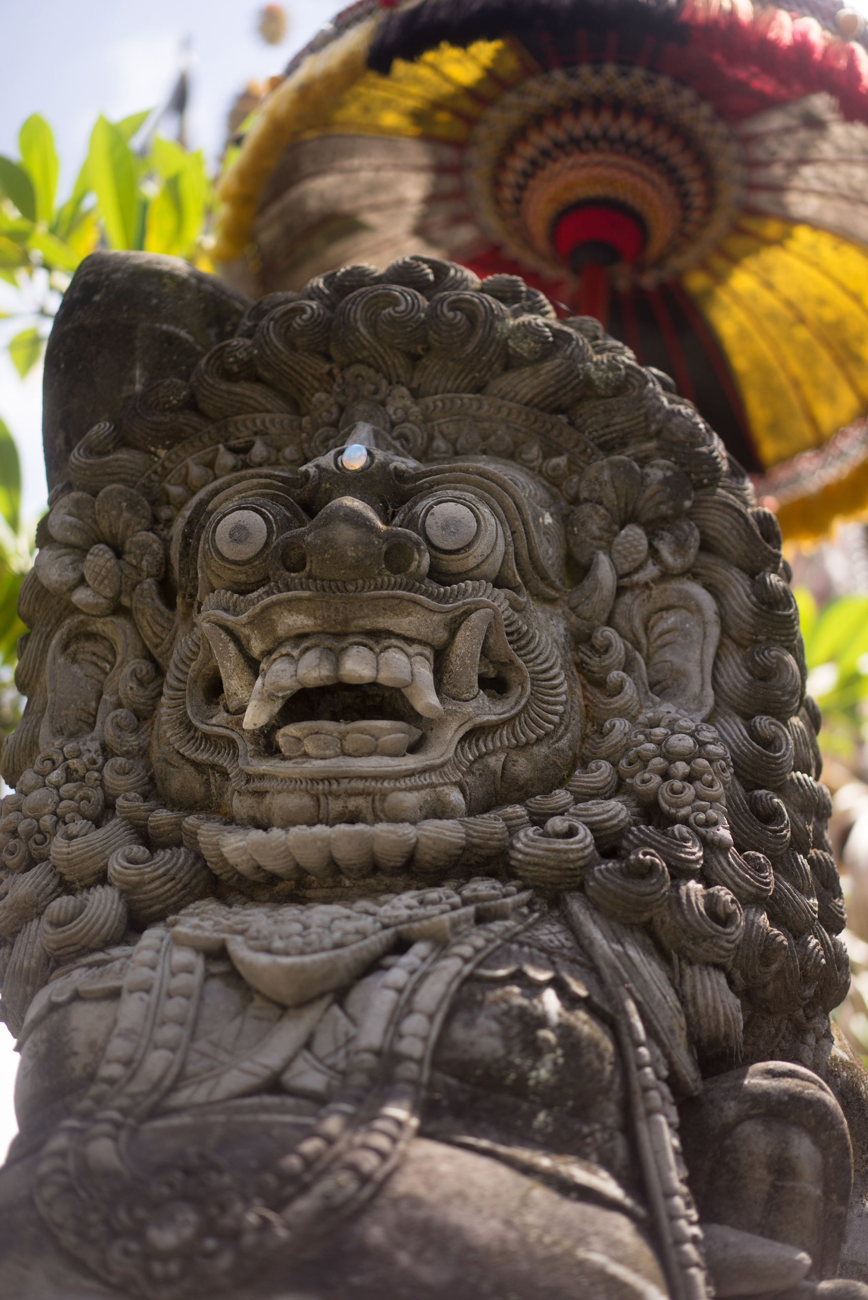 A Barong sits under its chatra with a pearl where it's third eye is