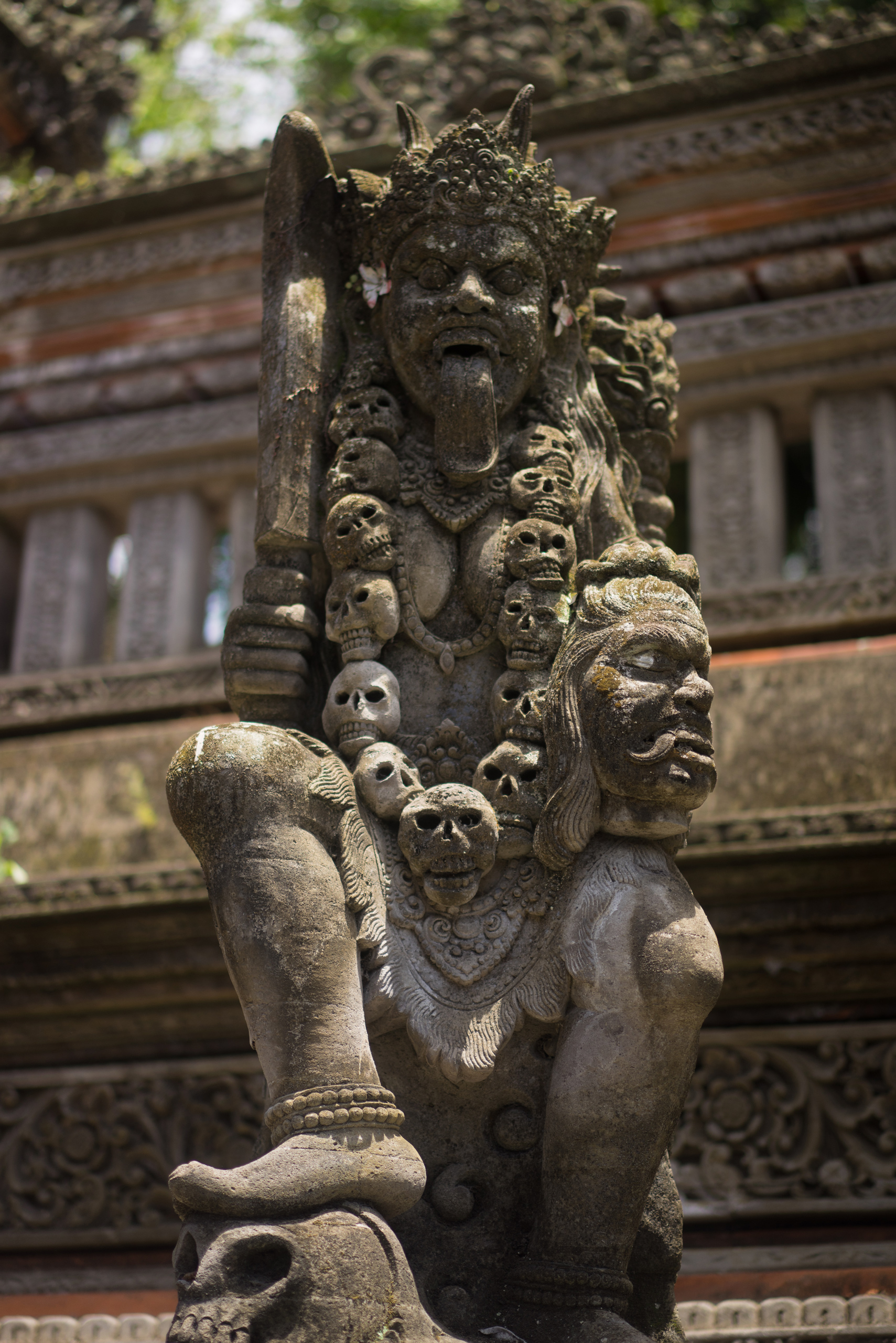 Kali holding a human head with her foot atop the skulls of other slain victims of her destruction