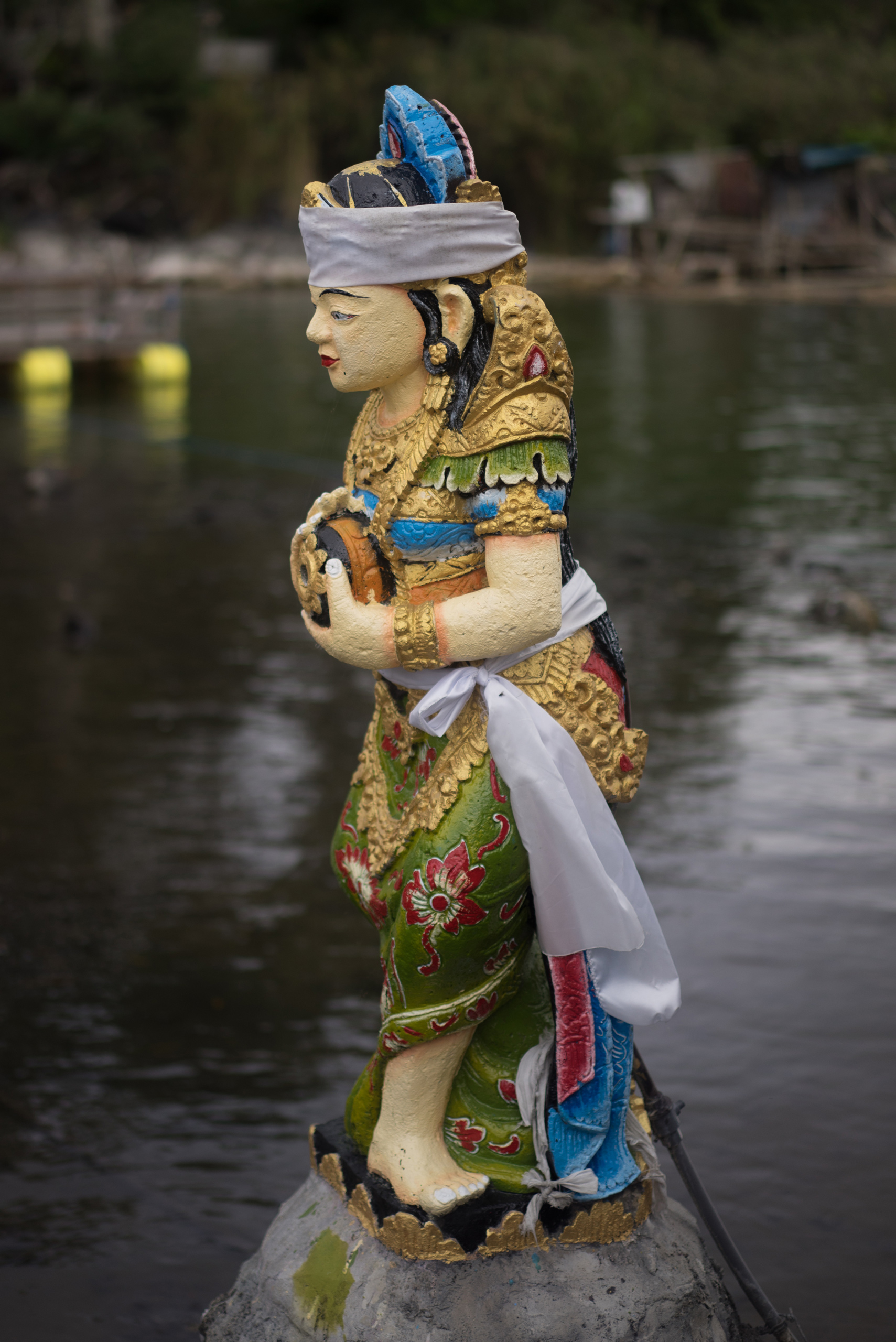 Bedogol colorful woman sits above the low waters