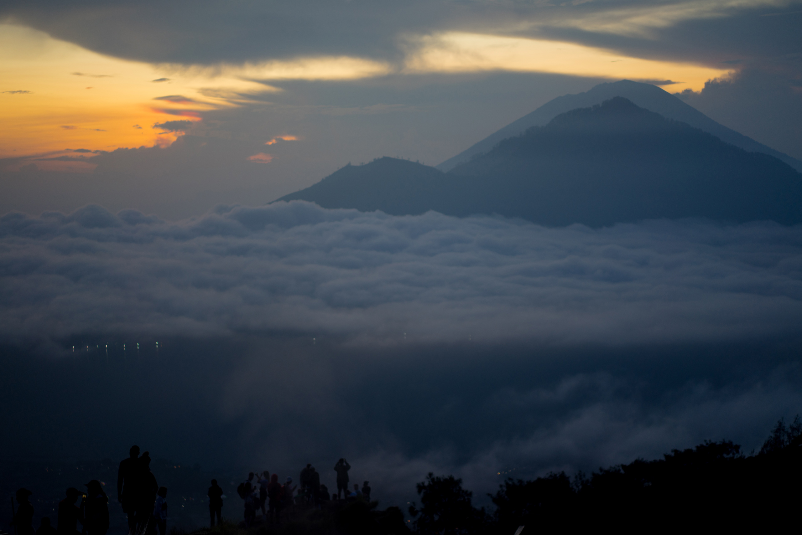 People gather atop Batur to watch the sunrise and the clouds roll in