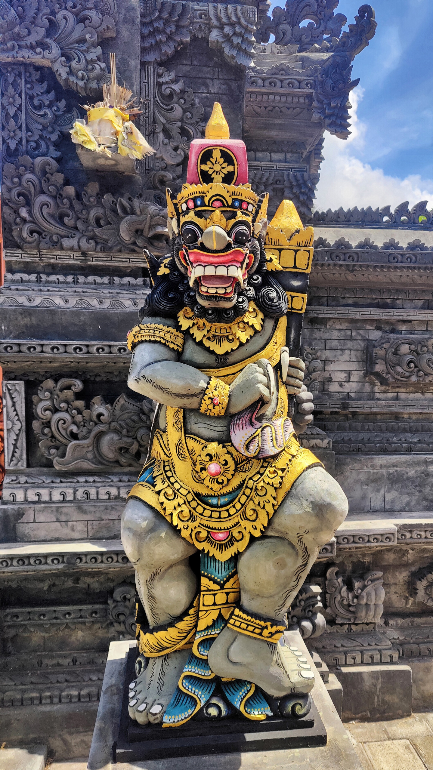 A painted guardian outside the little temple, with some monster calves